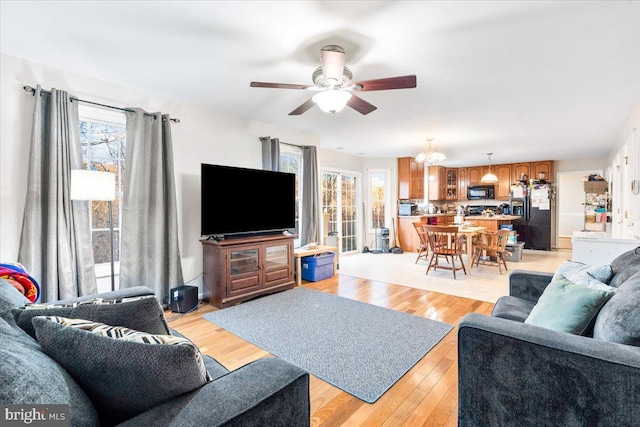 living area featuring ceiling fan, light wood finished floors, and a wealth of natural light