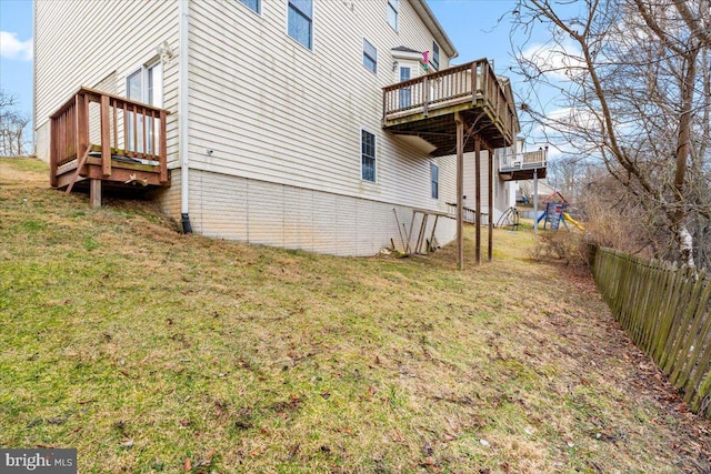 view of side of home featuring a yard, fence, and a deck