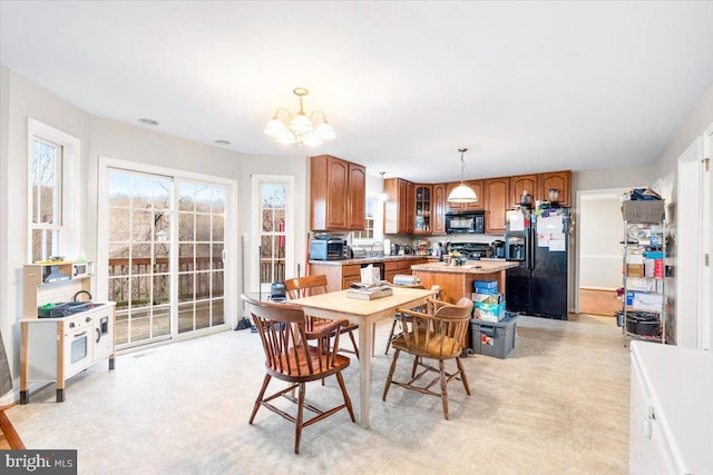 dining space with light floors, a notable chandelier, and a wealth of natural light