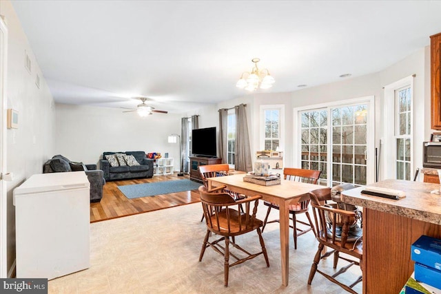 dining room featuring ceiling fan with notable chandelier