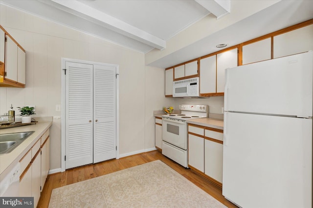 kitchen with beam ceiling, light countertops, white cabinets, a sink, and white appliances