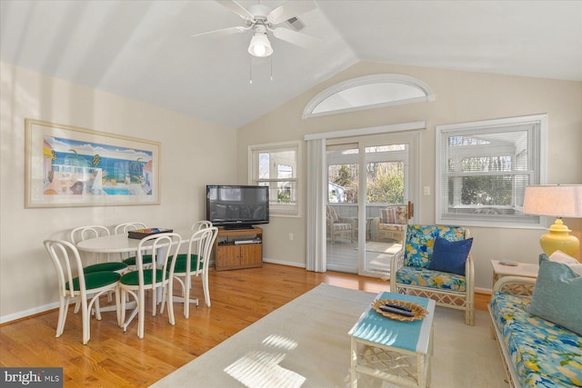 living area featuring a ceiling fan, lofted ceiling, baseboards, and wood finished floors