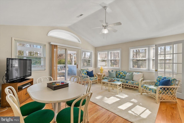 sunroom / solarium with lofted ceiling, ceiling fan, and visible vents