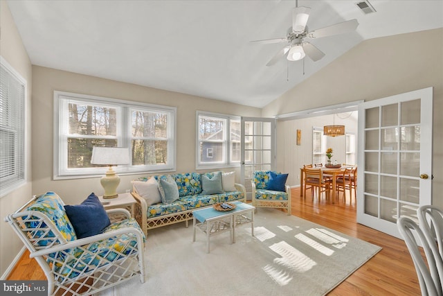 sunroom / solarium with a ceiling fan, lofted ceiling, and visible vents