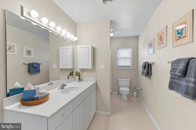 bathroom featuring baseboards, vanity, and toilet