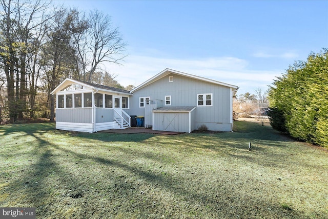 back of house featuring a lawn and a sunroom