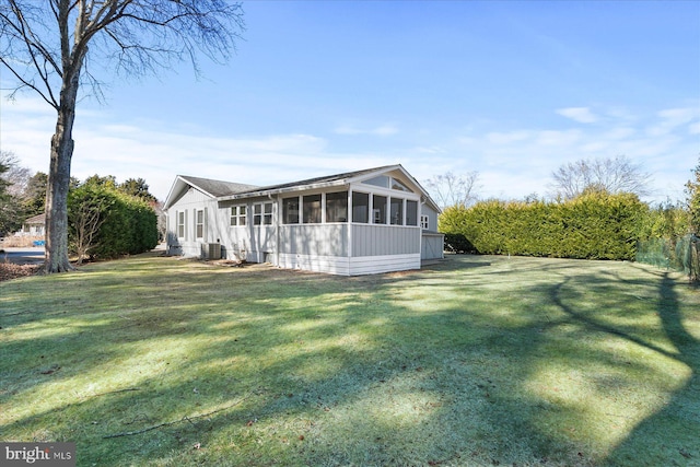 exterior space featuring a sunroom, central AC, and a yard