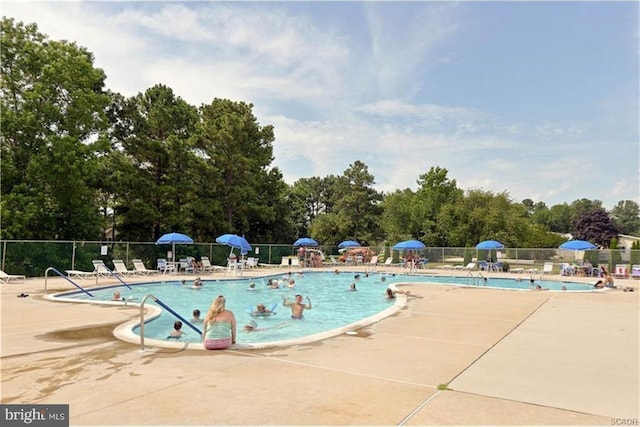 community pool with a patio and fence