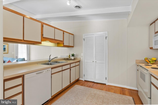 kitchen featuring white appliances, a sink, visible vents, white cabinetry, and light countertops