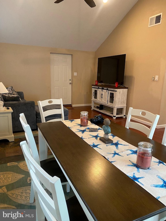 dining room with visible vents, baseboards, dark wood-style floors, ceiling fan, and vaulted ceiling