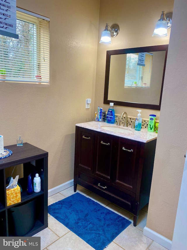 bathroom with tile patterned flooring, vanity, and baseboards