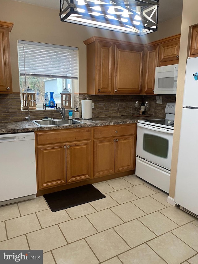 kitchen with tasteful backsplash, white appliances, a sink, and brown cabinets