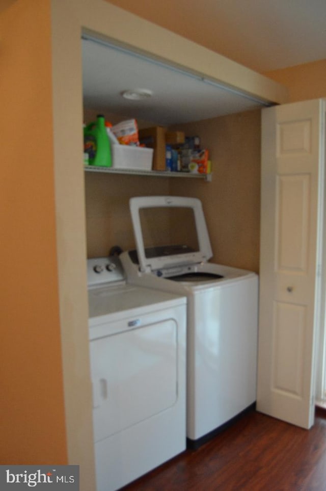 washroom featuring laundry area, washer and clothes dryer, and dark wood-style flooring