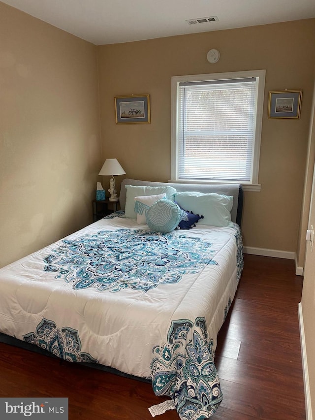 bedroom featuring baseboards, visible vents, and dark wood-type flooring