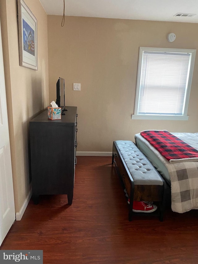 bedroom with dark wood finished floors, visible vents, and baseboards