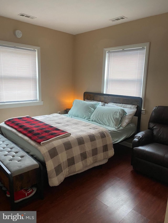 bedroom with dark wood-type flooring and visible vents