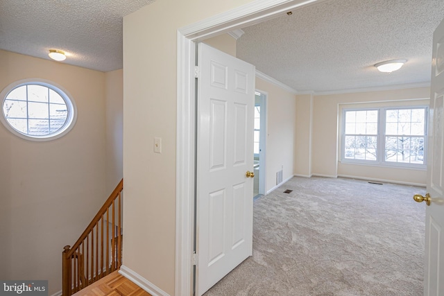 foyer entrance with a healthy amount of sunlight, visible vents, baseboards, and a textured ceiling