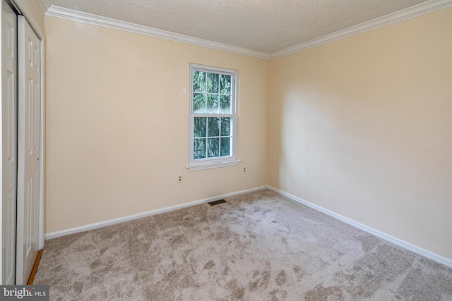 empty room featuring light carpet, visible vents, a textured ceiling, and ornamental molding