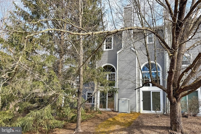 exterior space with a chimney and central AC unit