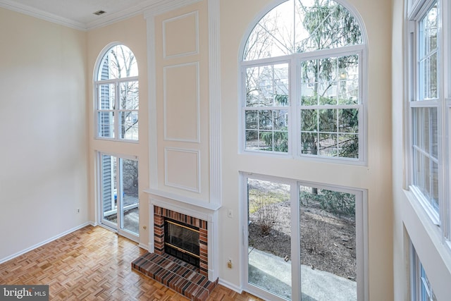 living room with ornamental molding, a high ceiling, a fireplace, and baseboards