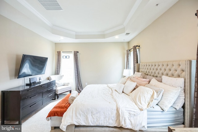 bedroom with a raised ceiling, carpet flooring, visible vents, and ornamental molding