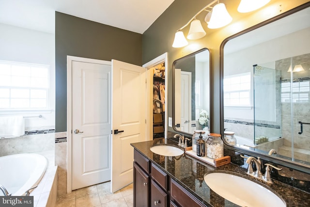 full bath with a sink, a garden tub, a stall shower, and double vanity