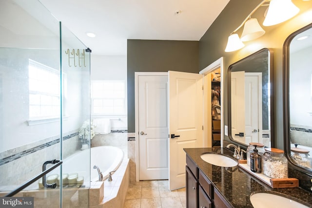 bathroom with a bath, tile patterned floors, double vanity, and a sink