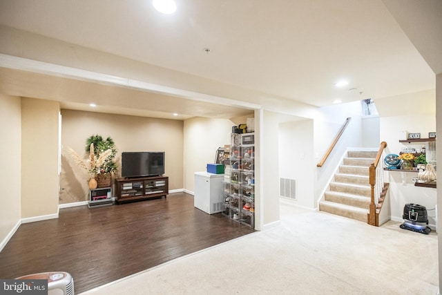 finished basement featuring visible vents, wood finished floors, recessed lighting, baseboards, and stairs