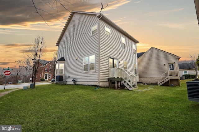 back of property at dusk with a lawn