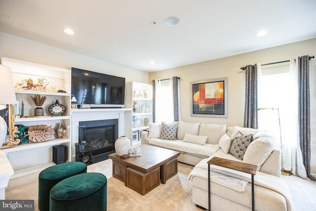 living room featuring a glass covered fireplace and recessed lighting