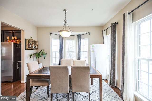 dining space featuring wood finished floors and baseboards