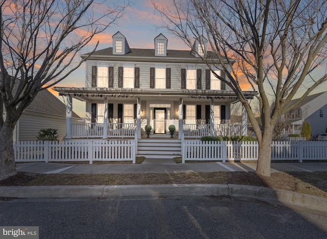 view of front facade with covered porch and a fenced front yard