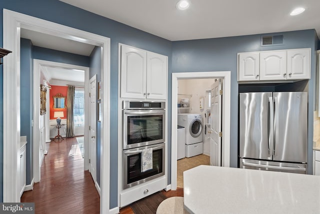 kitchen featuring appliances with stainless steel finishes, white cabinets, visible vents, and dark wood-type flooring