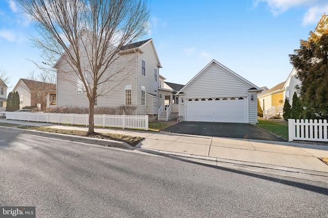 view of front of property with aphalt driveway, fence, and a garage