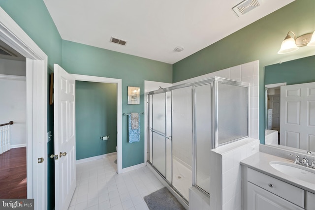 bathroom with a stall shower, tile patterned flooring, visible vents, and vanity