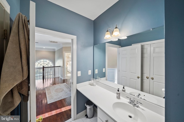 bathroom with wood finished floors, vanity, and baseboards