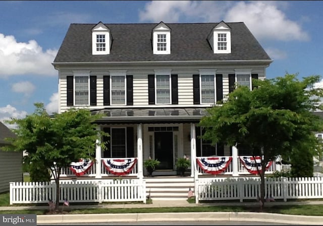 view of front facade with covered porch and a fenced front yard