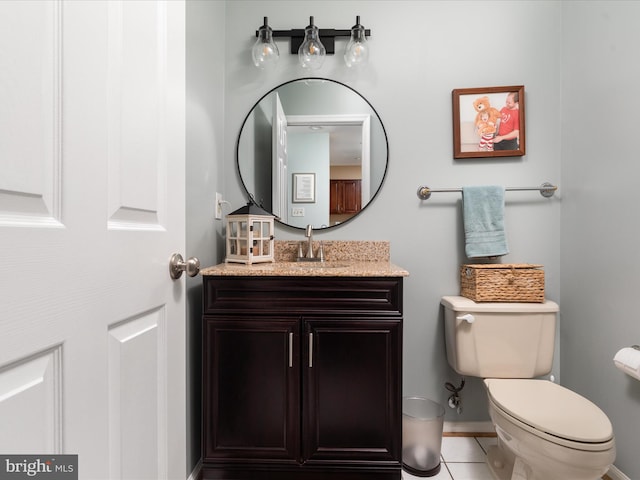 bathroom featuring toilet, tile patterned floors, baseboards, and vanity