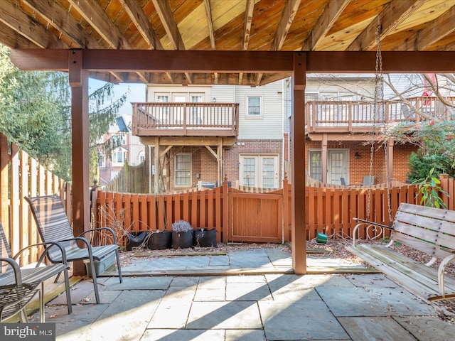 view of patio / terrace featuring fence and a balcony