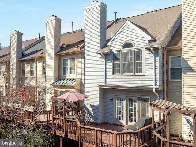 rear view of property with a shingled roof and a wooden deck