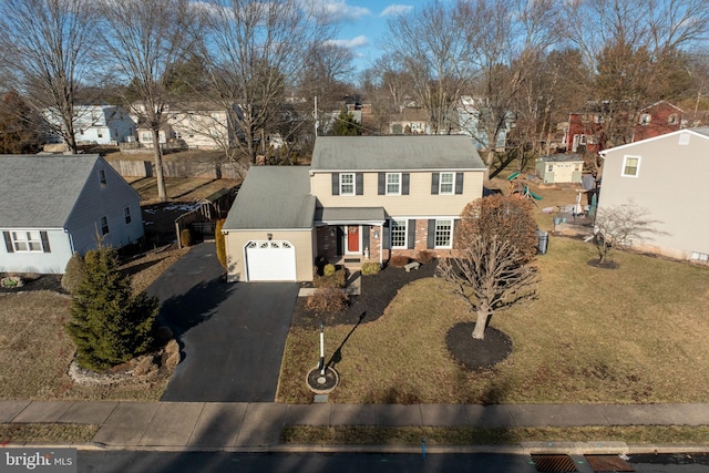 view of front of house featuring aphalt driveway, an attached garage, brick siding, a residential view, and a front yard