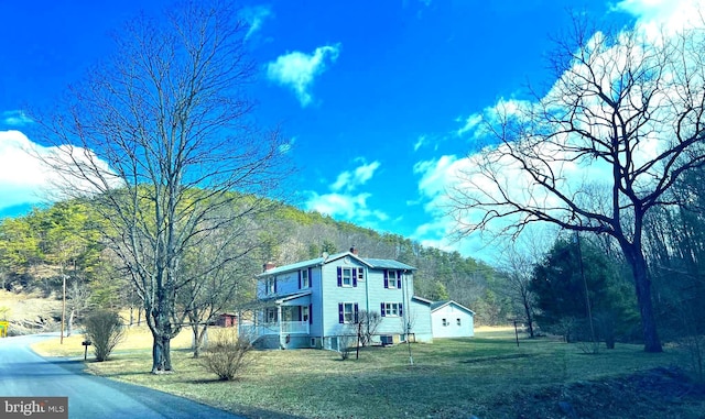 view of side of property with a yard and a chimney