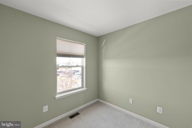 empty room with light colored carpet, visible vents, and baseboards