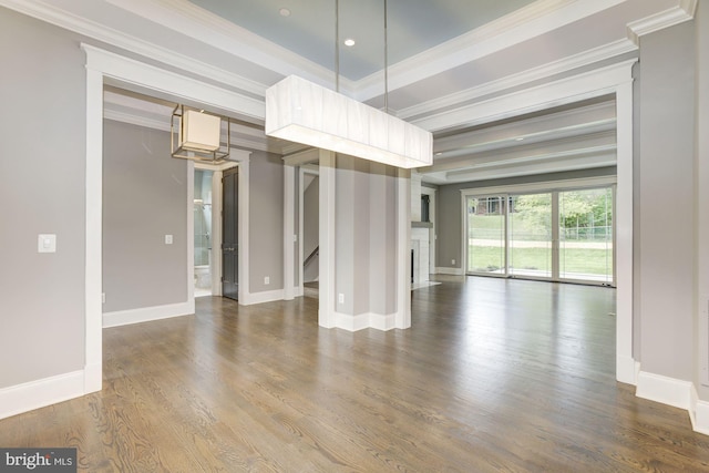 unfurnished dining area with baseboards, a fireplace, wood finished floors, and crown molding