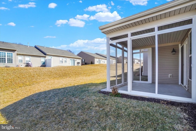 view of yard featuring a sunroom and a residential view