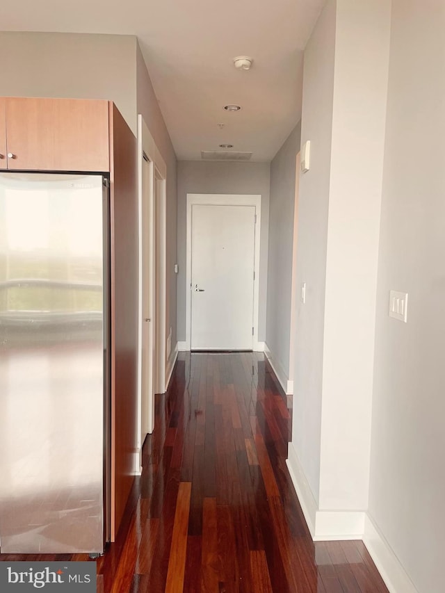 hallway with dark wood-style flooring and baseboards