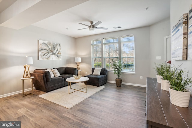 living room with a ceiling fan, baseboards, visible vents, and wood finished floors