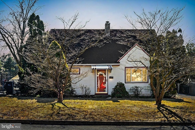 view of front facade with a chimney and a front yard