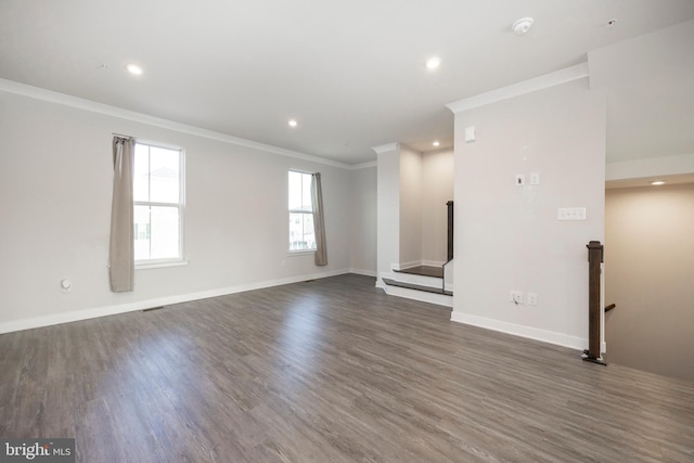 unfurnished living room with dark wood-style flooring, crown molding, and baseboards