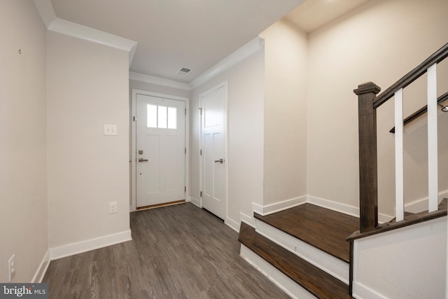 entrance foyer featuring crown molding, dark wood-type flooring, stairs, and baseboards